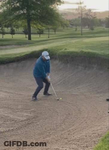 Man Swinging Golf Club At Ball In Bunker GIF