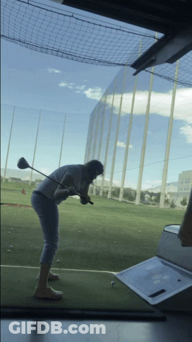Man Swinging Golf Club At Ball GIF