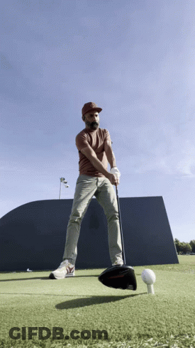 Man Swinging Golf Club At Golf Ball GIF