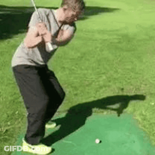 Man Swinging Golf Club At Golf Ball GIF