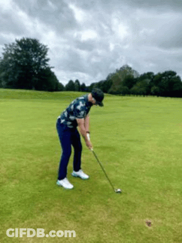 Man Swinging Golf Club At Golf Ball GIF