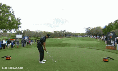 Man Swinging Golf Club At Golf Ball GIF