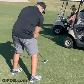 Man Swinging Golf Club Beside Golf Cart GIF