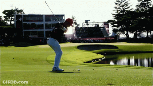 Man Swinging Golf Club In Front Of Tokyo 2020 Building GIF
