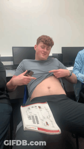 Man Taking Off Shirt Holding Book GIF
