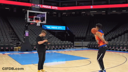 Man Taking Picture Of Basketball Player On Court With Proud City Sign GIF