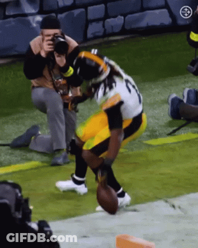 Man Taking Picture Of Football Player Holding Football GIF