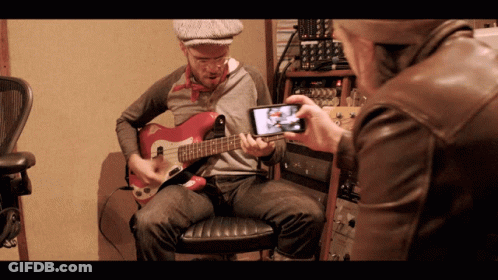 Man Taking Picture Of Guitarist GIF