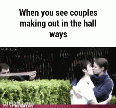 Man Taking Picture Of Kissing Couple In Hallway GIF