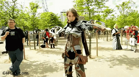 Man Taking Picture Of Woman In Costume With Sword GIF
