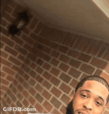 Man Taking Selfie In Front Of Brick Wall GIF