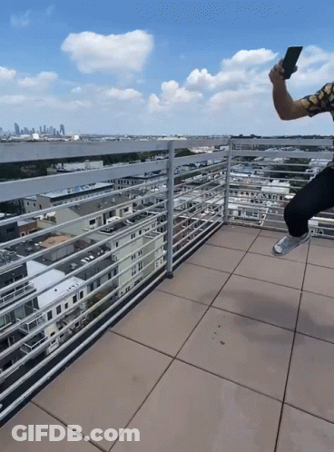 Man Taking Selfie On Balcony With City Background GIF