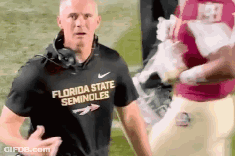 Man Talking Into Microphone In Front Of Farm Bureau Sign GIF