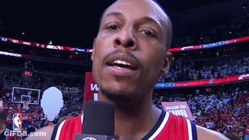 Man Talking Into Microphone In Front Of Wizards Win Sign GIF