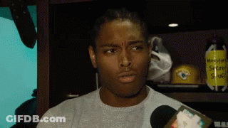 Man Talking Into Microphone In Locker Room With Secret Stuff Sign GIF