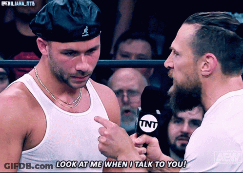 Man Talking Into TNT Microphone While Another Man Looks On GIF