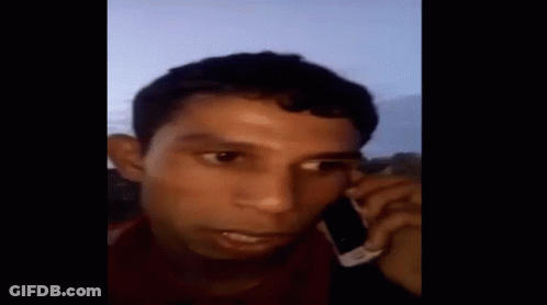 Man Talking On Cell Phone Covering Ears GIF