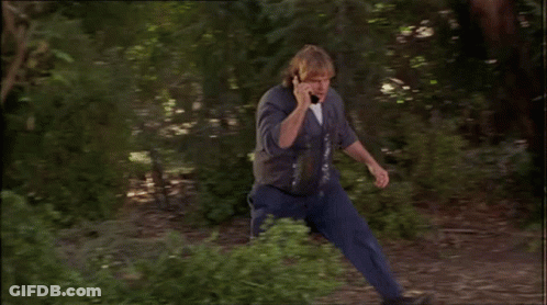 Man Talking On Cell Phone Leaning Against Tree Branch GIF