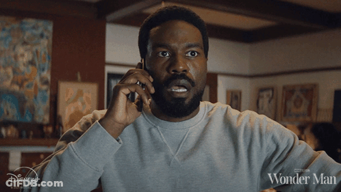 Man Talking On Cell Phone With Wonder Man Shirt GIF