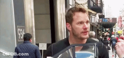 Man Talking To Another Man Holding Bag On City Street GIF