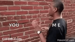 Man Talking To Himself At Brick Wall GIF