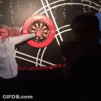 Man Throwing Dart At Red Rim Dart Board GIF