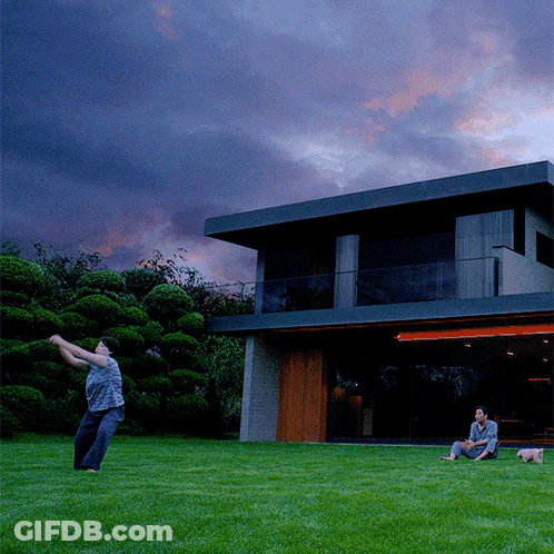 Man Throwing Frisbee In Front Of Large House GIF