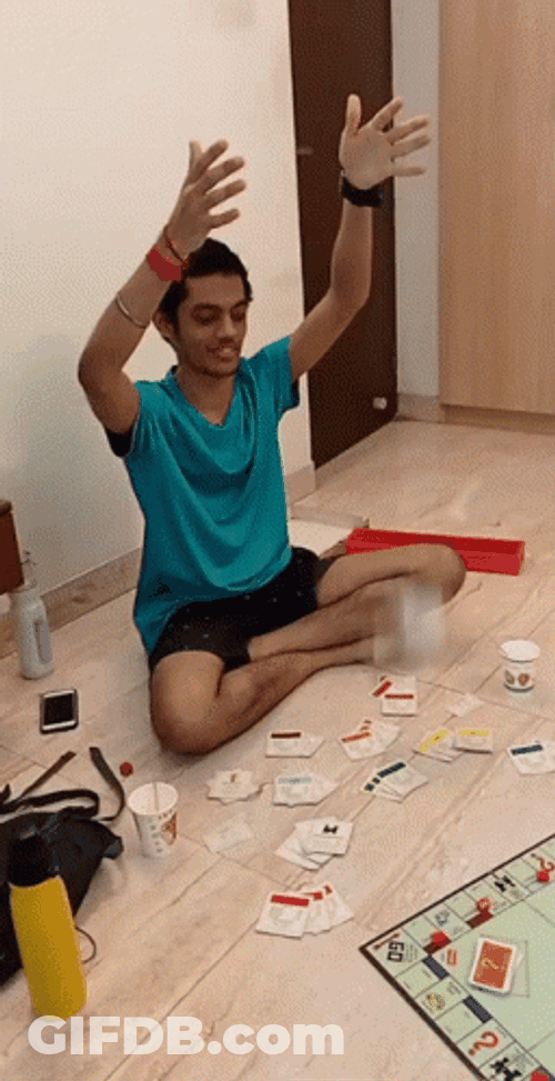 Man Tossing Monopoly Money While Sitting GIF
