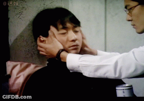Man Touching Another Man's Face In Blurry Photo With Chinese Writing GIF