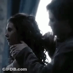 Man Tying Woman's Hair In Dark Room GIF