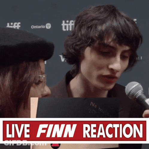 Man Using Microphone Beside Live Finn Reaction Sign GIF