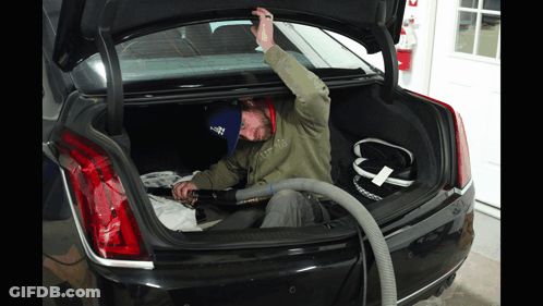 Man Using Vacuum In Car Trunk GIF