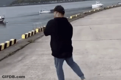 Man Walking Along Dock By Water GIF