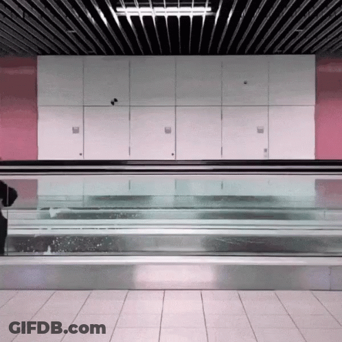 Man Walking Down Escalator With Blue Bag GIF