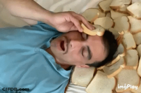 Man Walking Down Hallway With Chandelier And Red Couch GIF