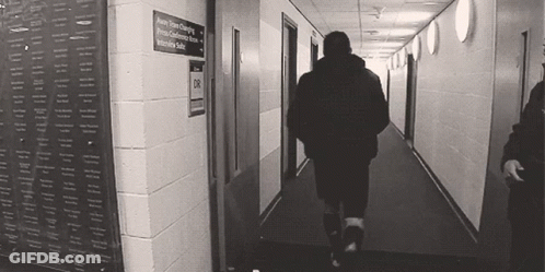 Man Walking Down Hallway With Intensive Suite Sign GIF