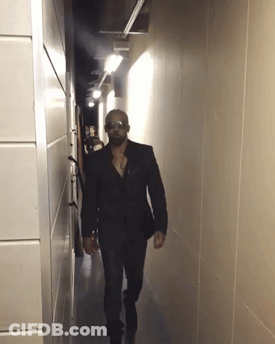 Man Walking Down Hallway With Sunglasses GIF