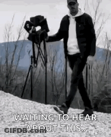 Man Walking Down Hill Holding Camera Waiting To Hear GIF