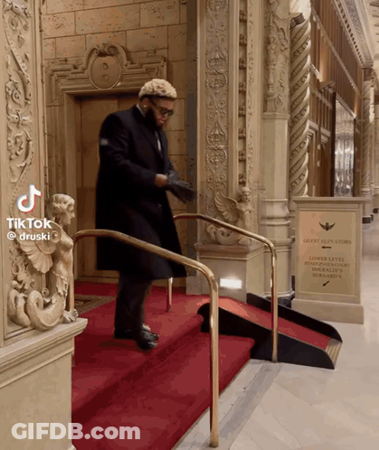 Man Walking Down Stairs With Guest Elevators Sign GIF
