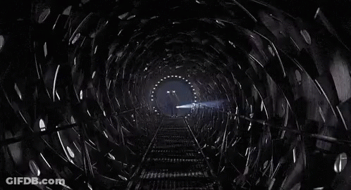 Man Walking Down Train Tracks In Dark Tunnel GIF