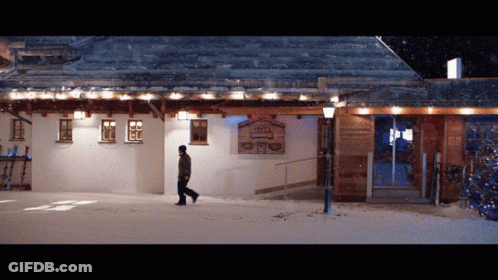 Man Walking In Front Of Building Sign GIF