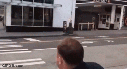 Man Walking In Front Of Exit Only Gas Station GIF