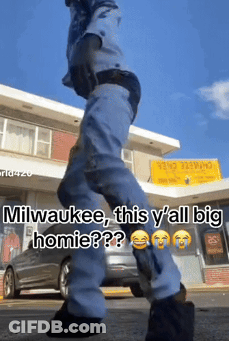 Man Walking In Front Of Milwaukee Building GIF