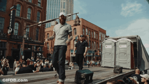 Man Walking In Front Of Whiskey Building GIF