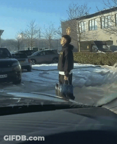 Man Walking In Parking Lot With Manchester United Logo GIF