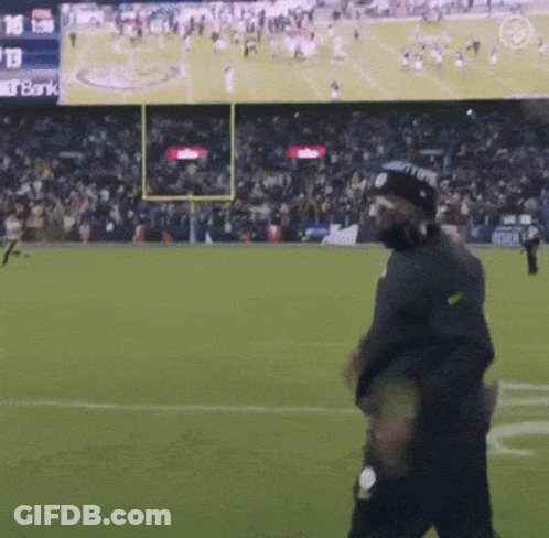 Man Walking On Football Field With Bank Screen GIF