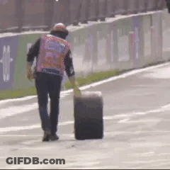Man Walking On Race Track With Tire GIF