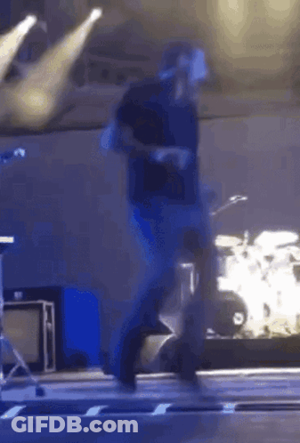Man Walking On Stage With Drum Set GIF
