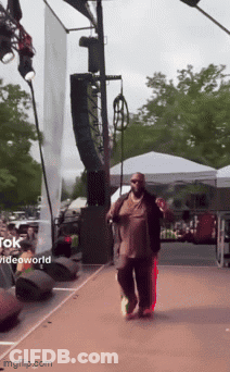 Man Walking On Stage With Videoworld Sign GIF