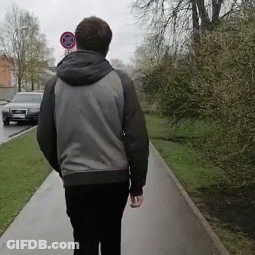 Man Walking Past No Parking Sign GIF